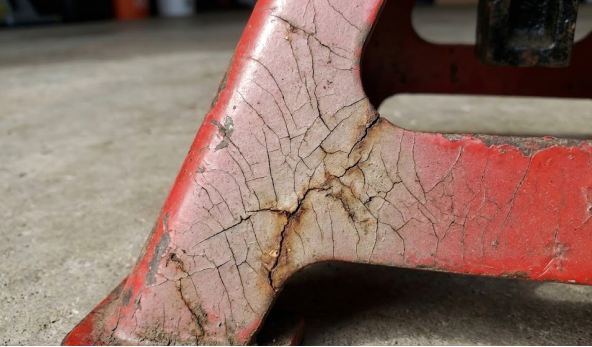 Cracked red jack stands show signs of wear and tear.