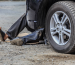 Person working unsafely under a car, highlighting the need for proper Jack Stands for safety.