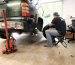 Man changing a truck tire, supported safely by reliable jack stands.