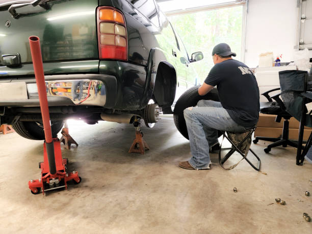 Man changing a truck tire, supported safely by reliable jack stands.