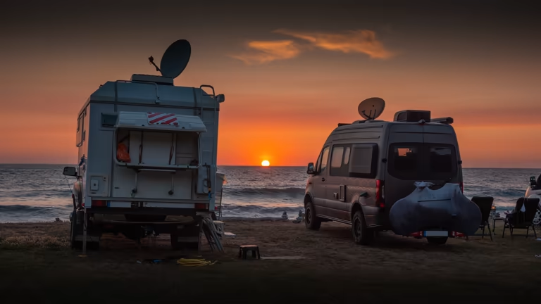 RVs parked on a serene beach at sunset. Jack stands ensure stability while camping.