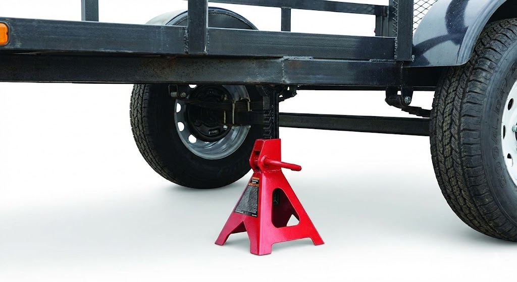 Red 2-ton jack stand supporting a trailer frame, essential for safe repairs.